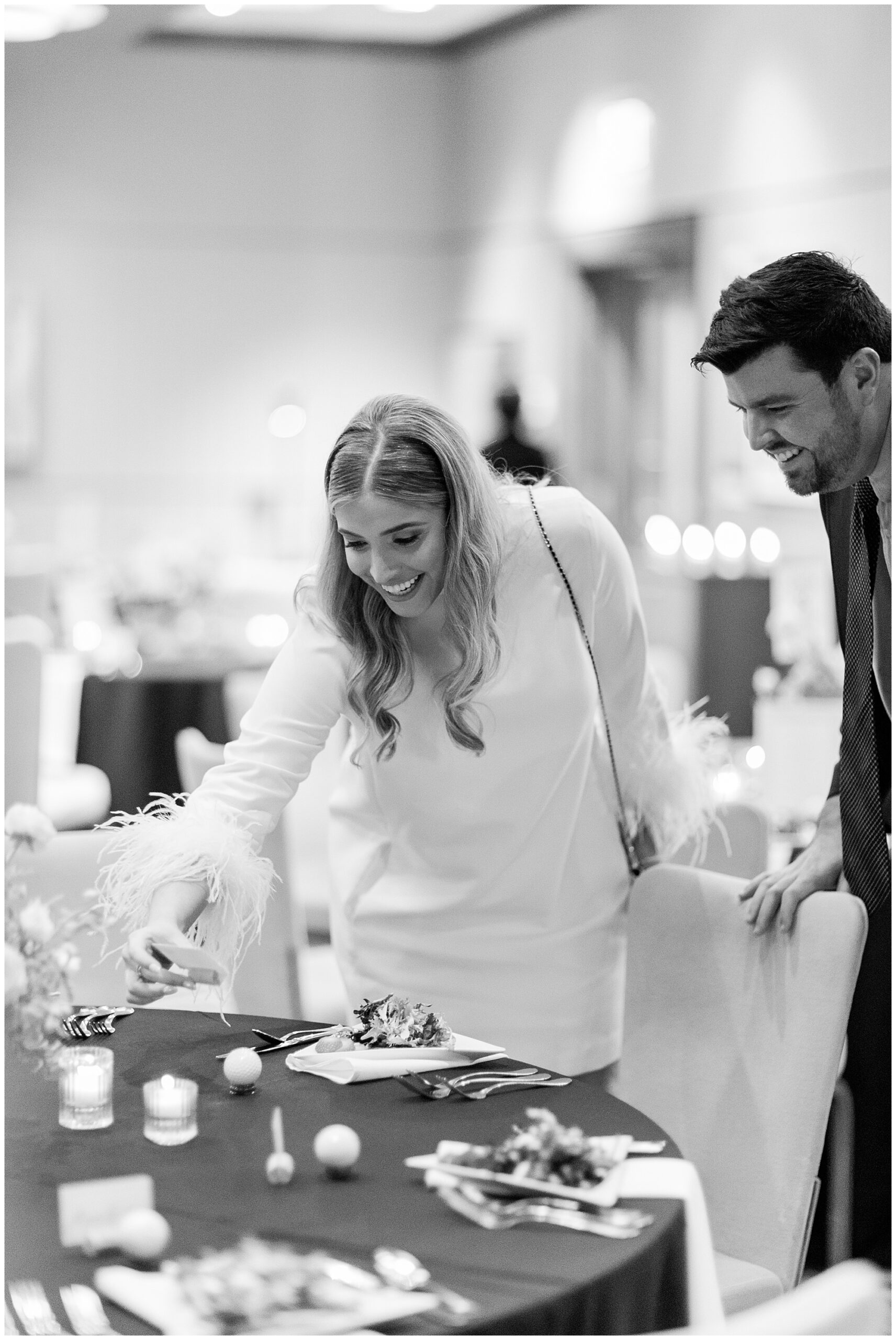 Faith, the bride, picks up one of the name cards to get a closer look at the adorable detail!