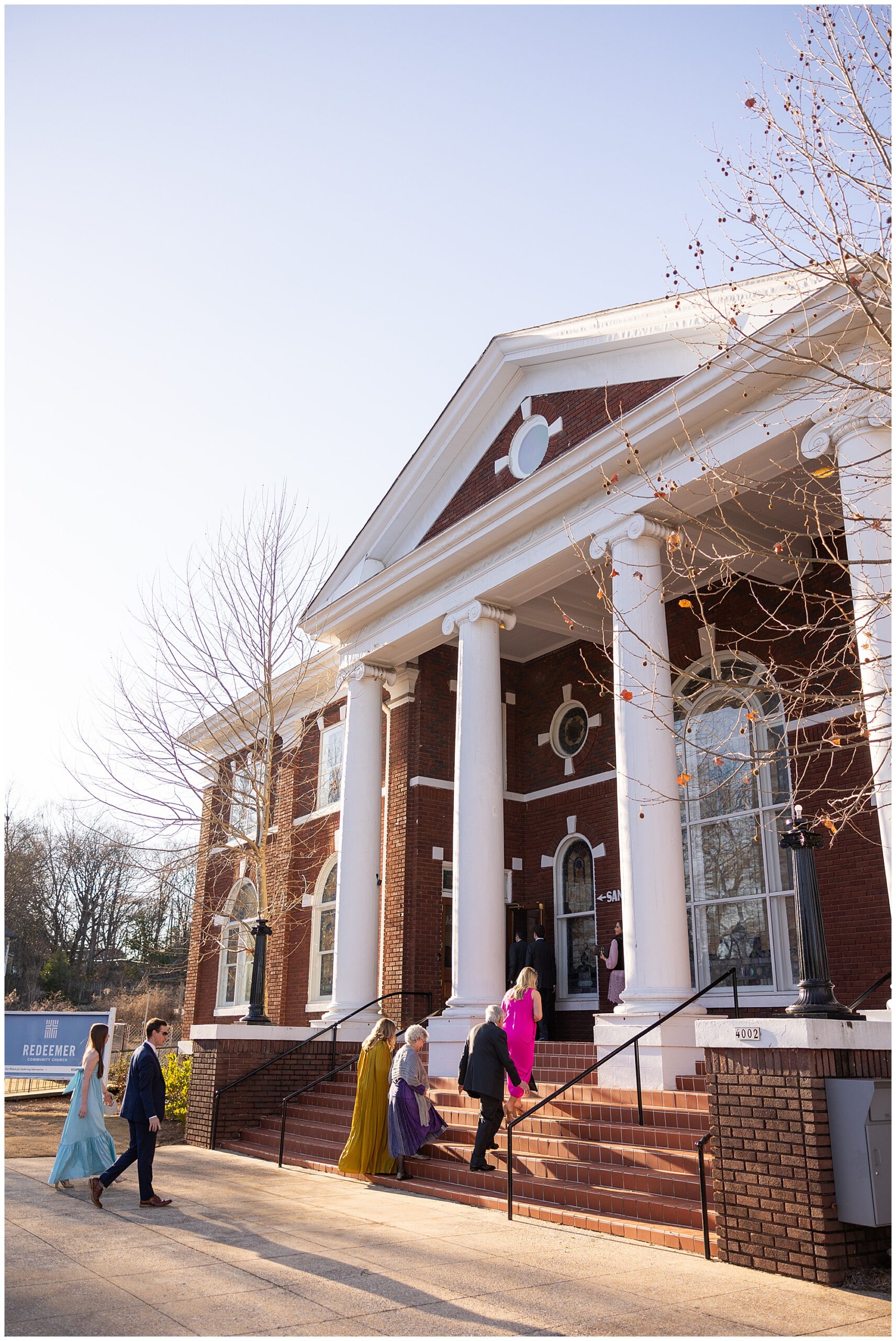 Guests are walking up the steps to enter the front doors of Redeemer Community Church. 