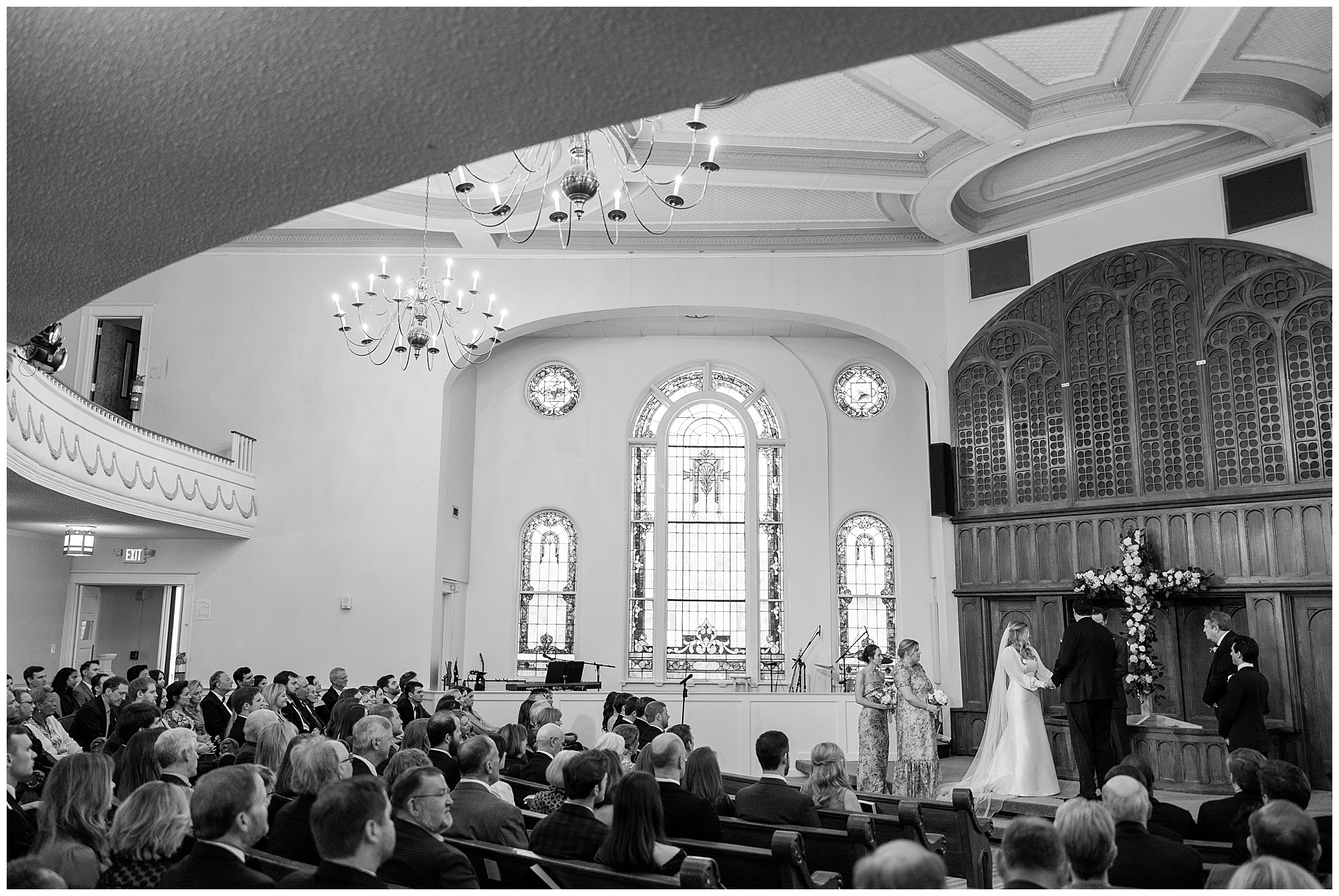 All of the guests sit and listen to the wedding ceremony at Redeemer Community Church. 