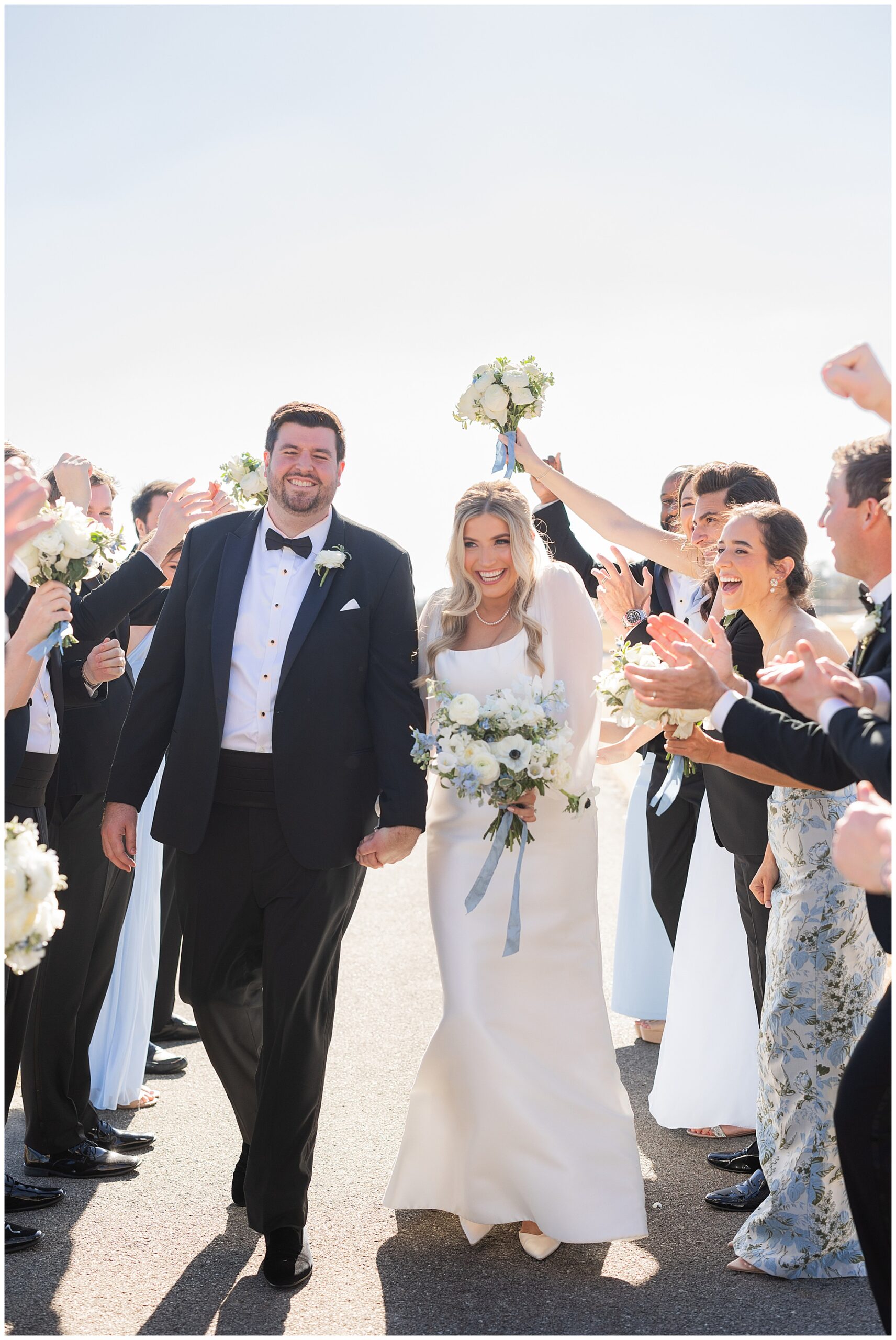 James and Faith, the bride and groom, smile while surrounded by their bridesmaids & groomsmen as they take photos at the Vestavia Country Club in Birmingham, AL. 