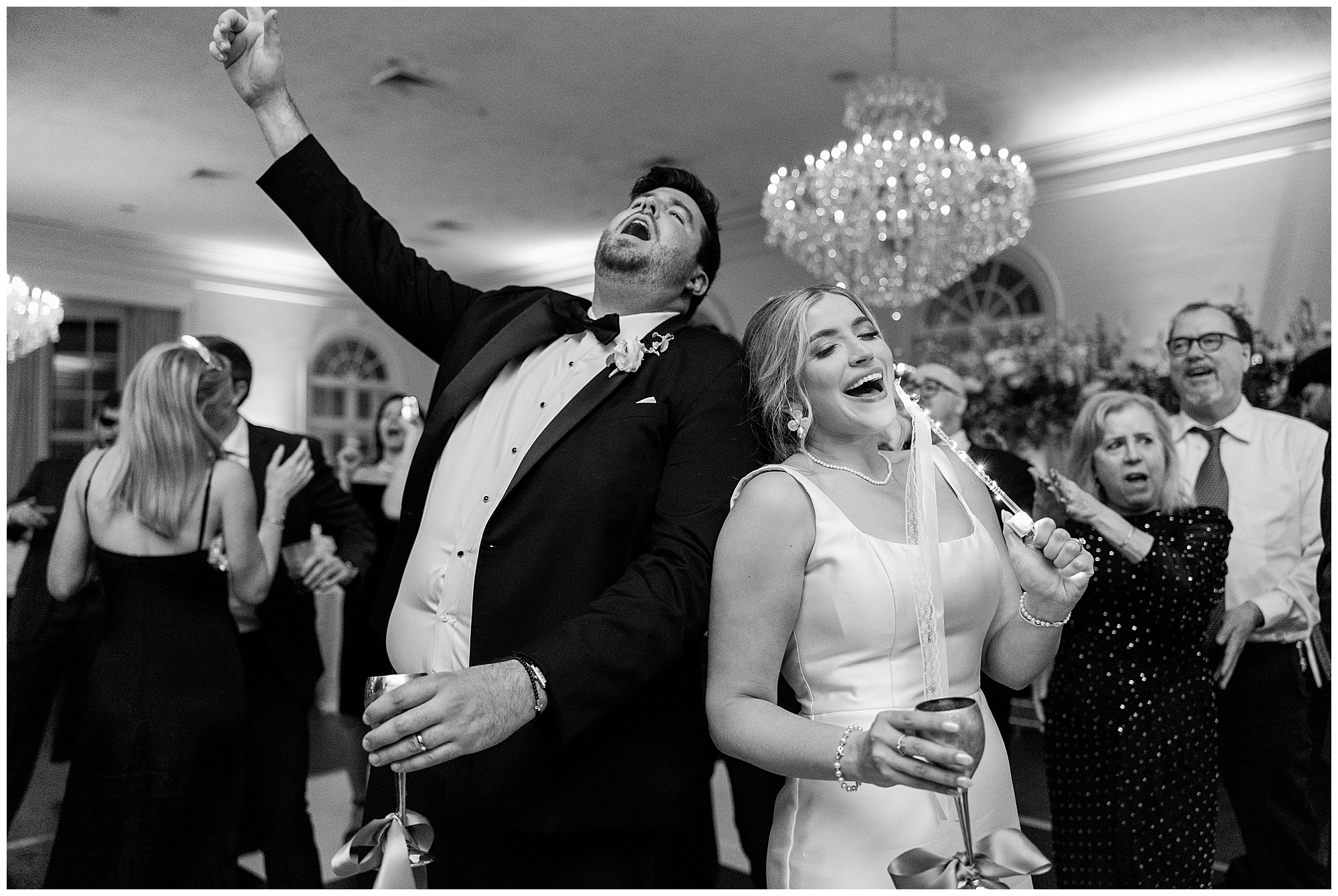 A black and white image of James and Faith singing along to the music on the dance floor. 