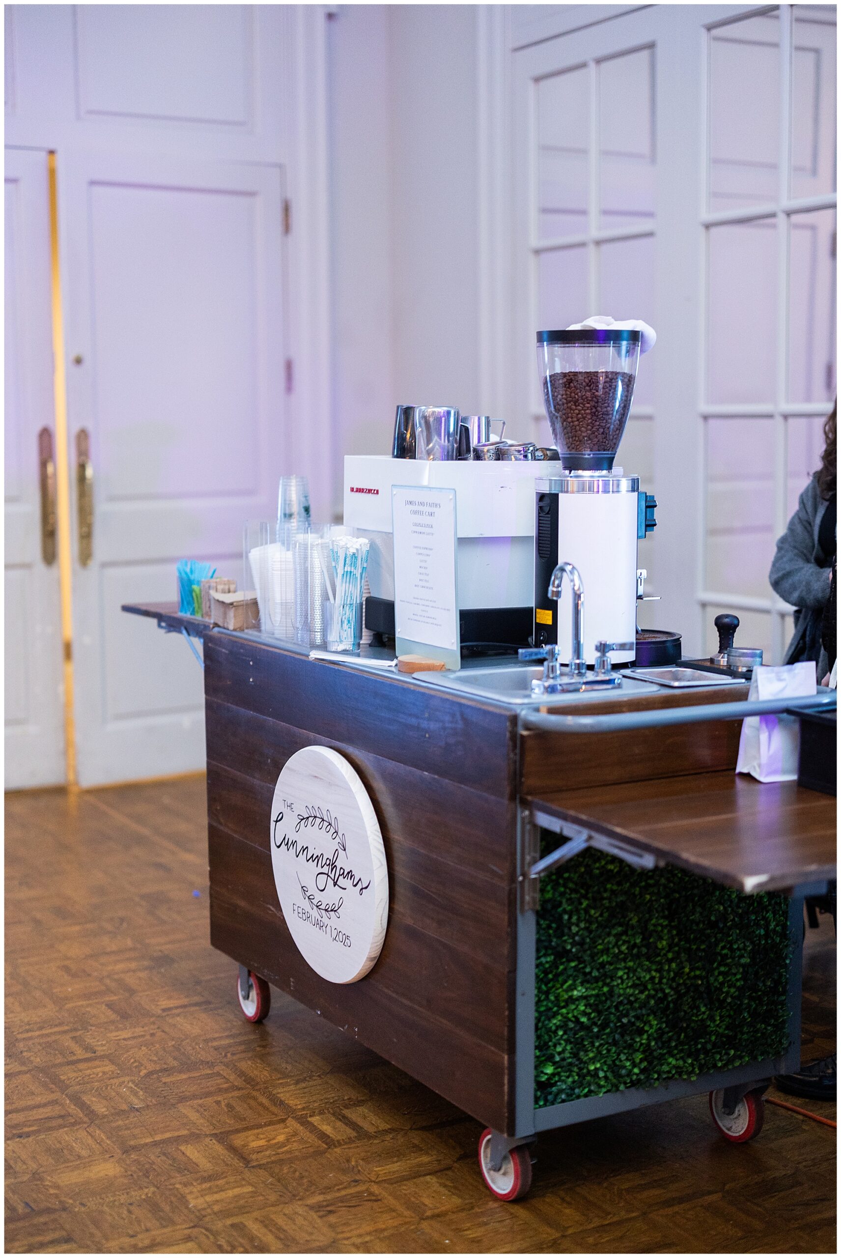 A coffee cart sits in the corner of the room for guests to come order coffee. 